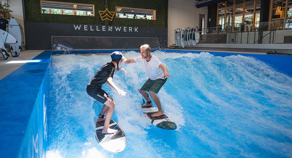 Coach und Teilnehmer gemeinsam auf der Welle beim Teamevent