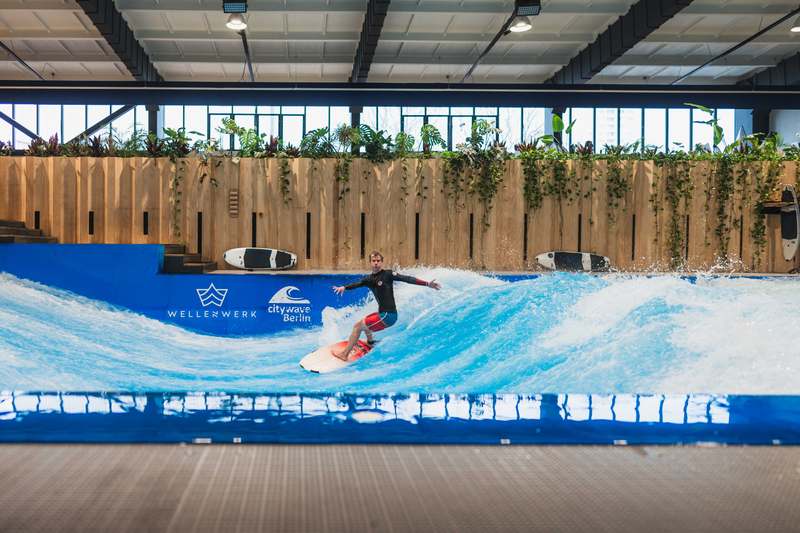 Advanced surfer riding free without a support bar, higher wave