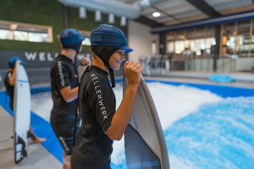 Kind beim Surfen mit Haltestange im Wellenwerk Berlin