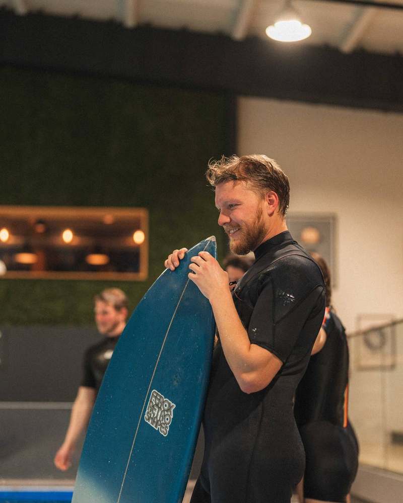 Strahlender Surfer mit Board nach der Session